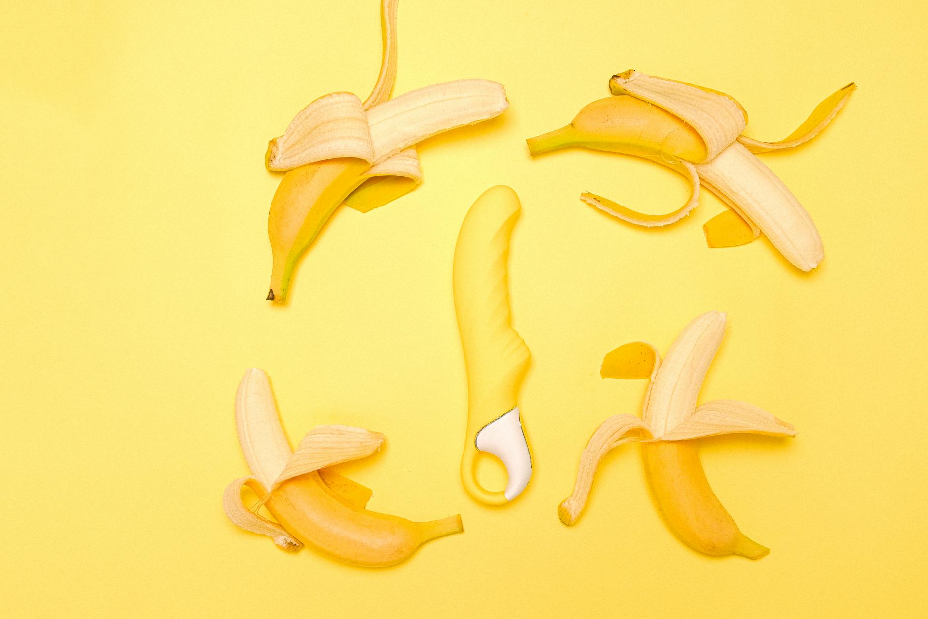 Yellow lemon vibrator surrounded by fresh citrus on a bright yellow background