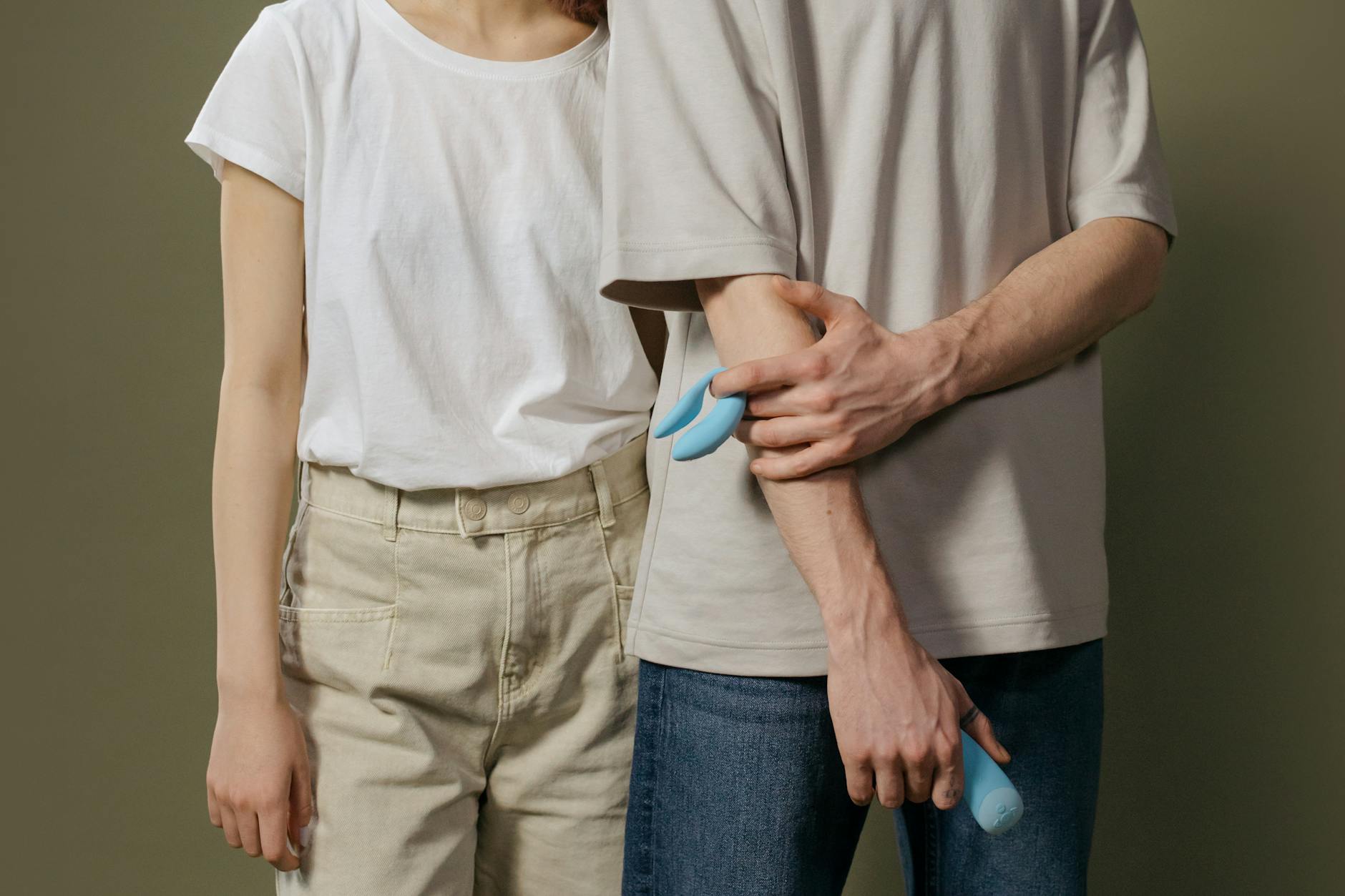 A blue silicone clitoral vibrator held in hand, representing self-directed pleasure and control